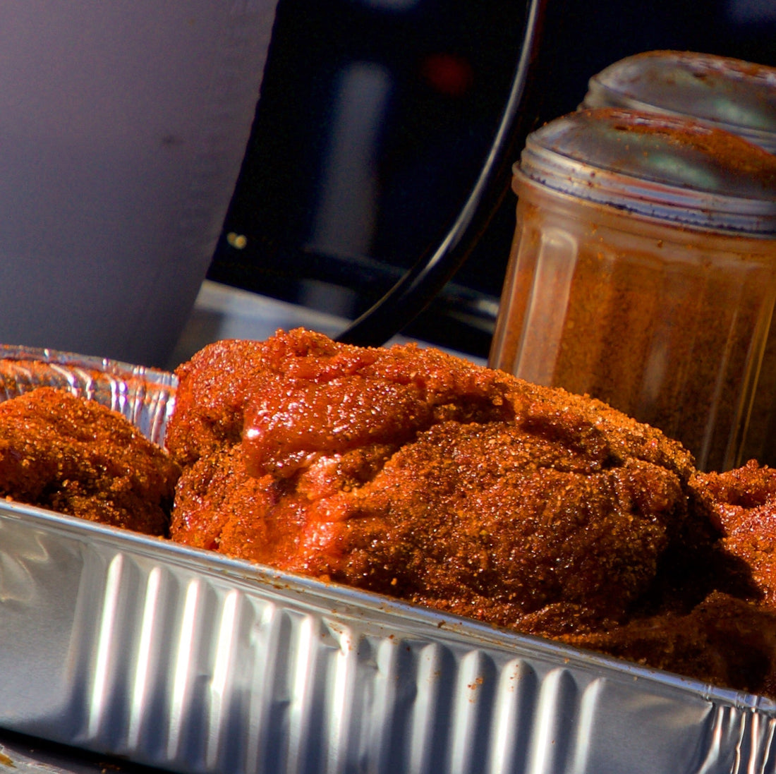 Pork Shoulder Boston Butt prepped and seasoned for BBQ in half pan with Rub Shaker